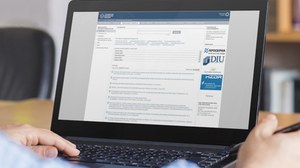 Das Foto zeigt einen Laptop-Monitor, auf welchem die Webseite des Forschungsinformationssystems zu sehen ist.
