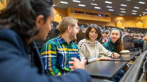 Fotos von vier sich unterhaltenden Studierenden in einem vollen TUD-Hörsaal.