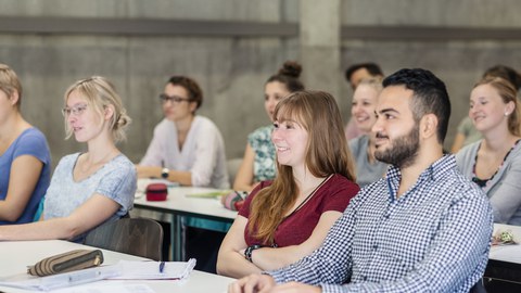 Foto mehrerer Personen, die einem Seminarraum sitzen