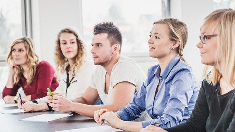 Studierende an einem Tisch in einem Workshop