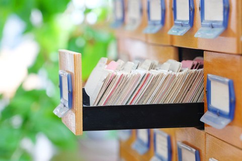 Altes Karteisystem Bibliothek mit geöffneter Schublade vor frischem Grün als Hintergund