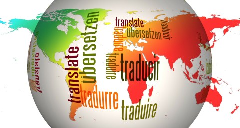 bunte Weltkugel mit dem Wort Translate in verschiedenen Sprachen