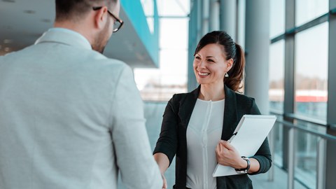 Business people handshake near the office building windows.