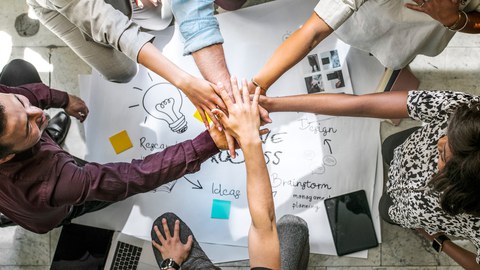 Diverse startup business team stacking hands