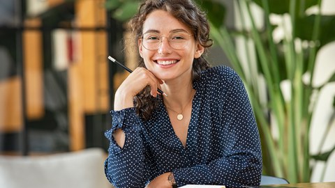 Portrait of happy smiling woman at desk