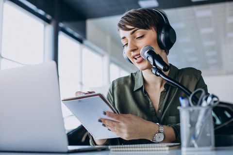 Young woman with microphone recording voice acting