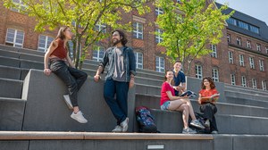 Bild zeigt 5 Studierende, die sich auf den Treppen am Fritz-Foerster-Bau unterhalten und zusammen lernen. 