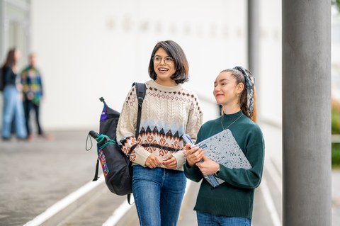 Bild von zwei lächelnden Studierenden auf dem TUD-Campus. 
