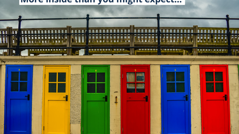 Colorful doors on the beach above sky in autumn  with slogan: More inside than you might expect!