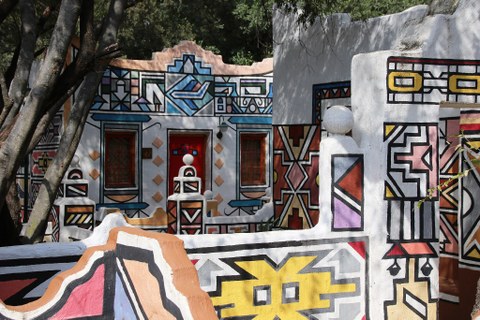 mit bunten geometrischen Mustern bemalte Häuser der Ndebele