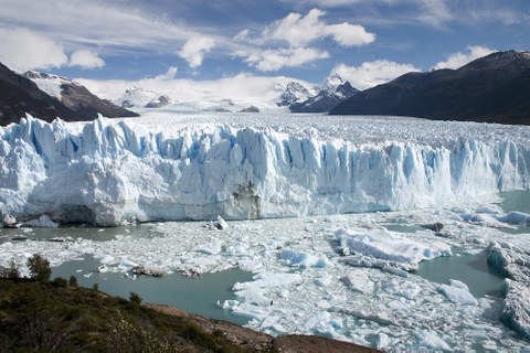 front of a giant glacier that ends in a lake