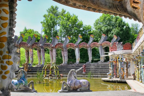 statues and a fantastical arcade surrounding a pond