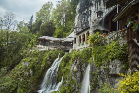 small castle at a cave mouth with waterfalls