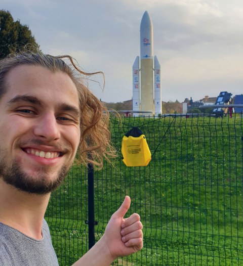 TUD student in front of the model of an Ariane rocket
