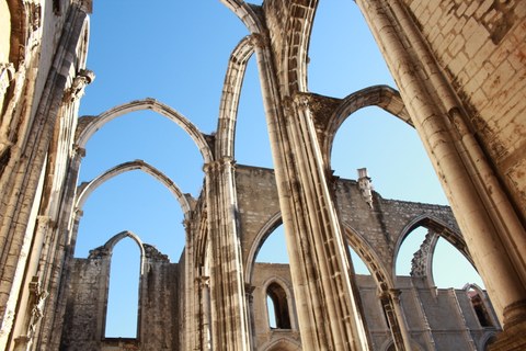 ruin of a gothic church, the roof is gone, only the arches are still standing