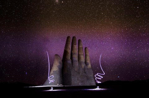 Die riesige Skulptur eine Hand ragt in den Sternenhimmel