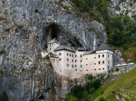 Eine Burg Höhle ragt aus einer Höhle im Fels heraus