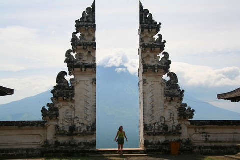 a gate in a temple, as if cut from the picture, opens to a mountain view