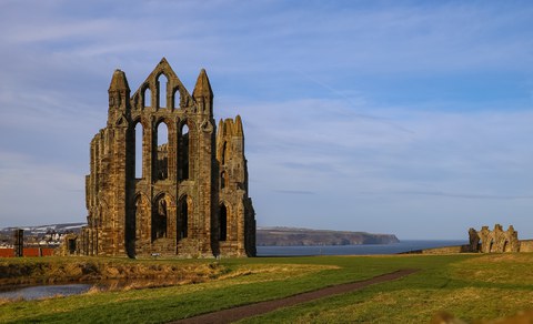 Die Ruine einer gotischen Kirche auf einer grünen Wiese am Meer