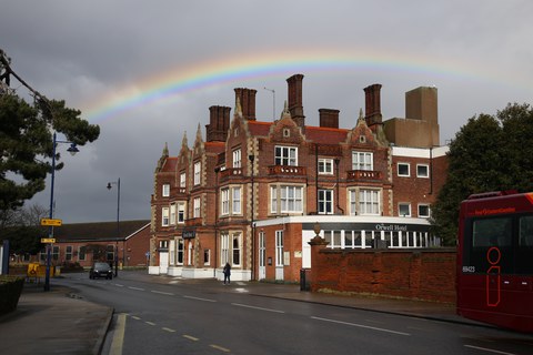 street with brick houses and a rainbow above