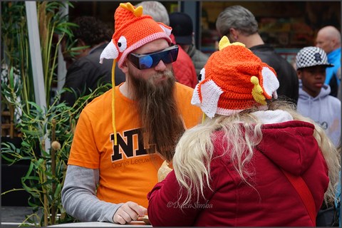 Menschen tragen orange Fischhüte zum Koningsdag