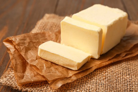 A stick of butter on baking paper