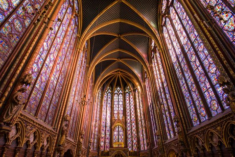 In der Innenansicht einer Kirche sieht man zu allen Seiten große, filigran gestaltete Buntglasfenster. Darüber ein gotisches Gewölbe