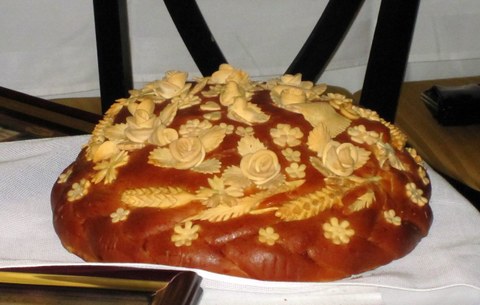 bread loaf elaborately decorated with ears of wheat and flowers made of dough