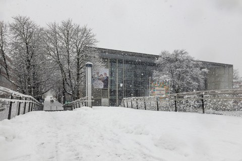 Das Foto zeigt das Hörsaalzentrum der TU Dresden und im Vordergrund die Brücke. Es schneit sehr stark und die Brücke ist völlig zugeschneit.