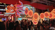 Foto am Abend in Taiwan, Menschen gehen auf der Straße die mit bunten Ballons gschmückt istehen