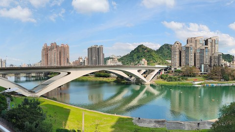 Foto von Taiwan, eine Brücke über einen Fluss, im Hintergrund stehen Hochhäuser