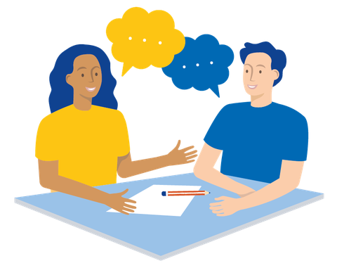 Zwei Personen sitzen sich an einer Tischecke gegenüber und sprechen miteinander. Vor ihnen liegen ein Blatt Papier und ein Stift.