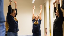 Drei Studierende strecken ihre Arme während des Pausen-Yogas.