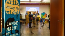 Beim Blick durch die Tür das Klemperer-Saals sieht man das Schreibimpulsrad, das am Anfang des Schreibprozess-Walkes steht. Ein Roll-Up zur Langen Nacht des Schreibens steht an der Seite.