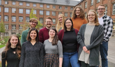 Ten employees of the writing center are standing on a staircase, all smiling at the camera.