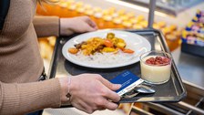 Studentin mit Essenstablett an der Mensakasse