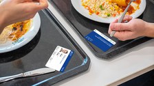 Zwei Mensatabletts mit Essen und Campuscards