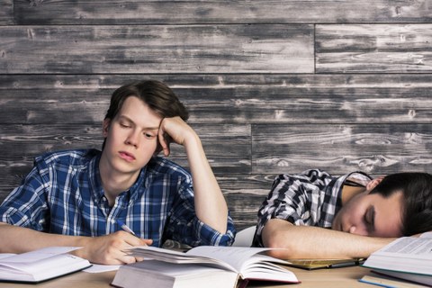 Zwei müde Studenten am Schreibtisch