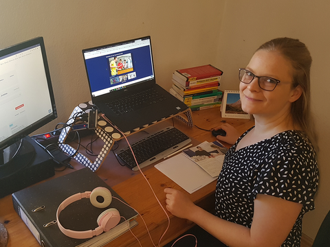 Studienberaterin sitzt zu Hause am Schreibtisch vor ihrem Computer.