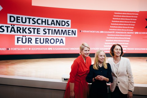 Das Foto zeigt Sabrina Repp, EU-Parlamentarierin Katarina Barley und Ministerpräsidentin Manuela Schwesig vor einer Bühne. Im Hintergrund ist ein SPD-Banner mit dem Schriftzug ‚Deutschlands stärkste Stimmen für Europa‘ zu sehen.