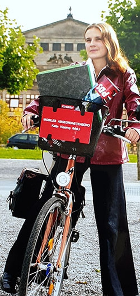 Das Foto zeigt Katja Kipping als junge Abgeordnete auf ihrem Fahrrad.