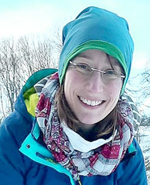 Portrait photo of Franziska Iltzsche. She is outside and wearing a hat and scarf.