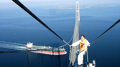 The photo shows Dr. Zwieg on a bridge cable 250 meters above the water.