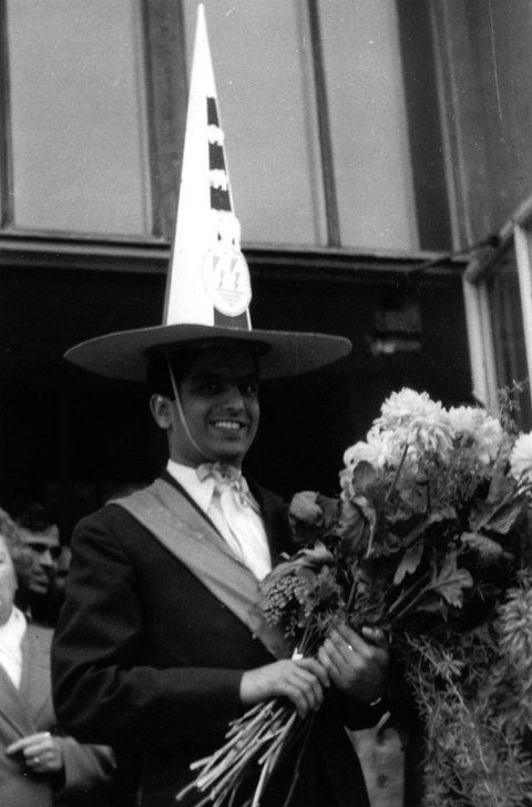 Foto eines Mannes mit Blumenstrauß und Doktorhut