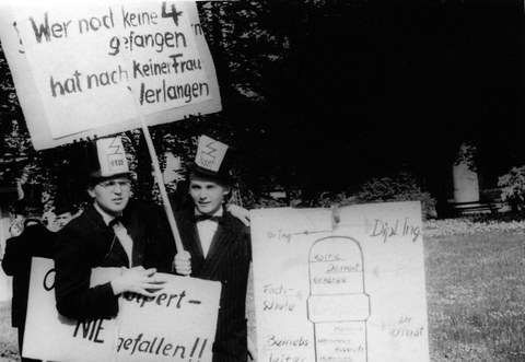 Foto zweier Herren mit einem Schild in der Hand