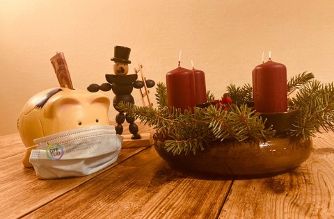 Sparschwein mit Maske in weihnachtlichem Setting