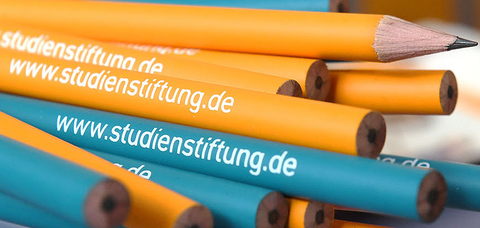 Bleistifte in orange und blau mit dem weißen Schriftzug www.studienstiftung.de