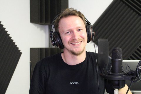 Portrait von Ralph vom Campusradio. Er sitzt in einem Tonstudio. 