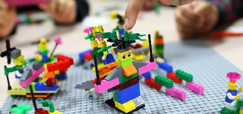 Das Foto zeigt verschiedene bunte Legofiguren auf einer Legoplatte.