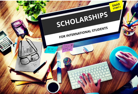 Picture of a workstation with a computer. On the desktop, the words "SCHOLARSHIPS FOR INTERNATIONAL STUDENTS".